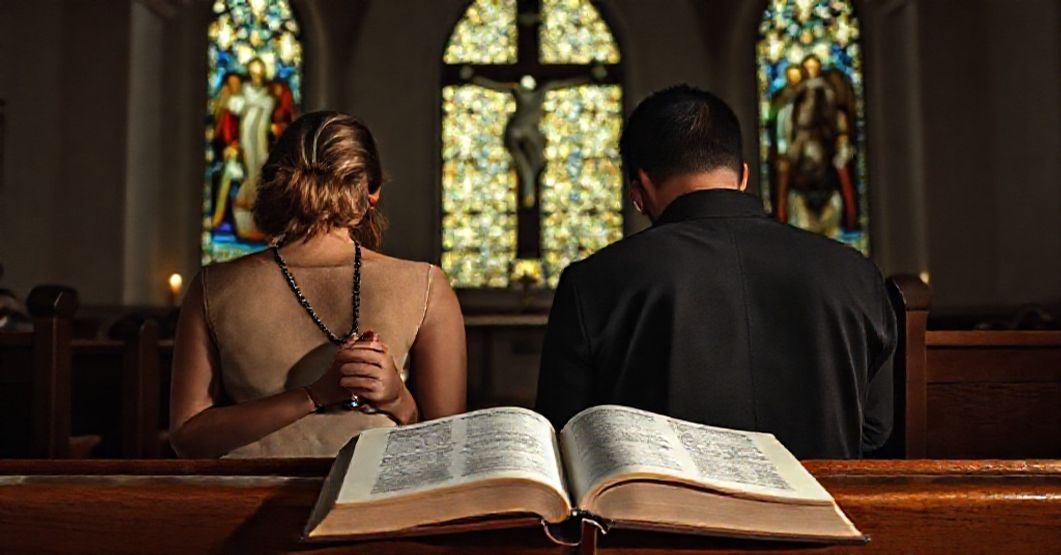 A Catholic couple praying before a crucifix in a church, emphasizing traditional marriage and openness to life.