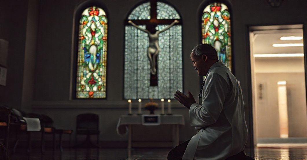 A Catholic doctor in traditional clerical attire kneeling in prayer before a crucifix in a hospital chapel, reflecting on moral compromises in modern medicine.