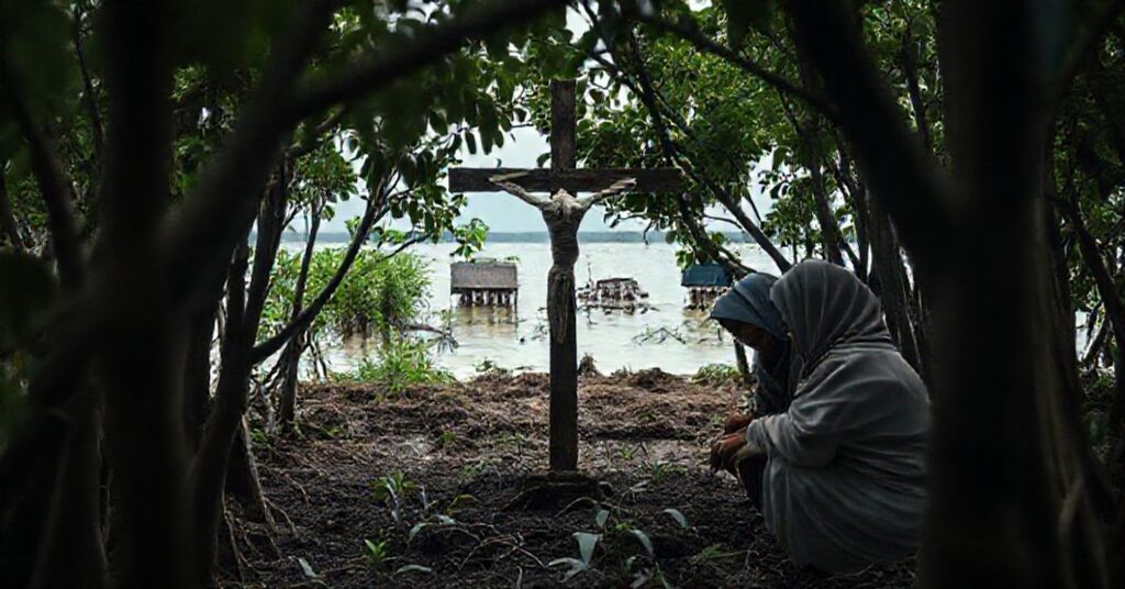Sr. Vincentia Sabarina HK and Muslim collaborators planting mangroves in Indonesia with a faded crucifix in the background.