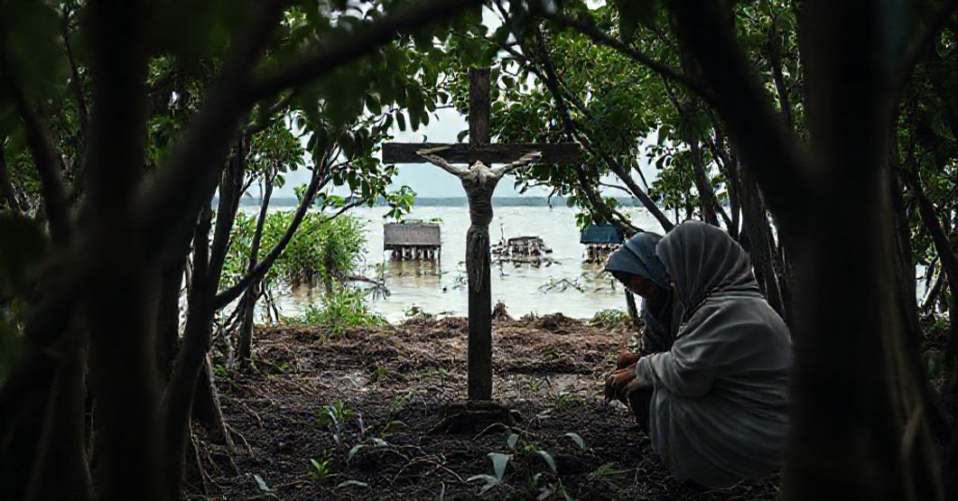 Environmental Syncretism Masquerading as Catholic Charity in Indonesia Sr. Vincentia Sabarina HK and Muslim collaborators planting mangroves in Indonesia with a faded crucifix in the background.